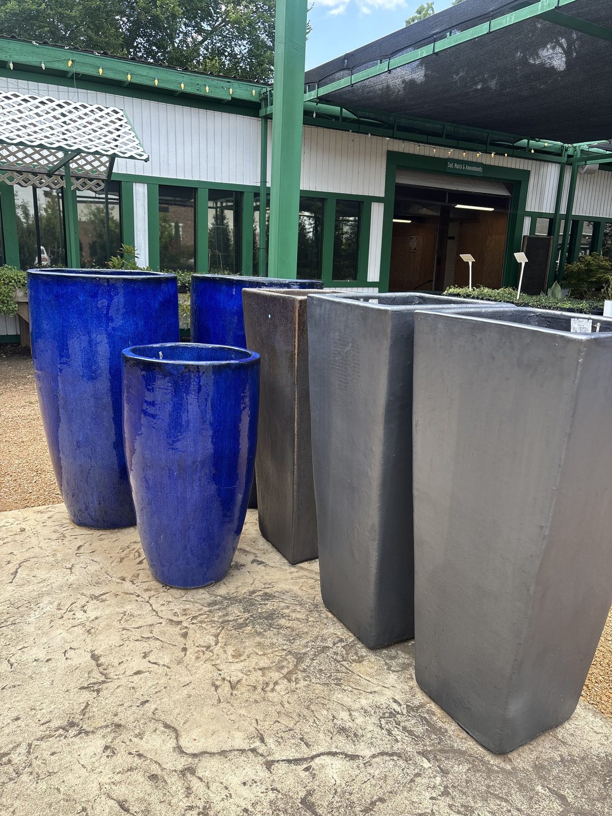 Glazed cobalt blue and charcoal planters in the pottery selection at Land Care Garden Center